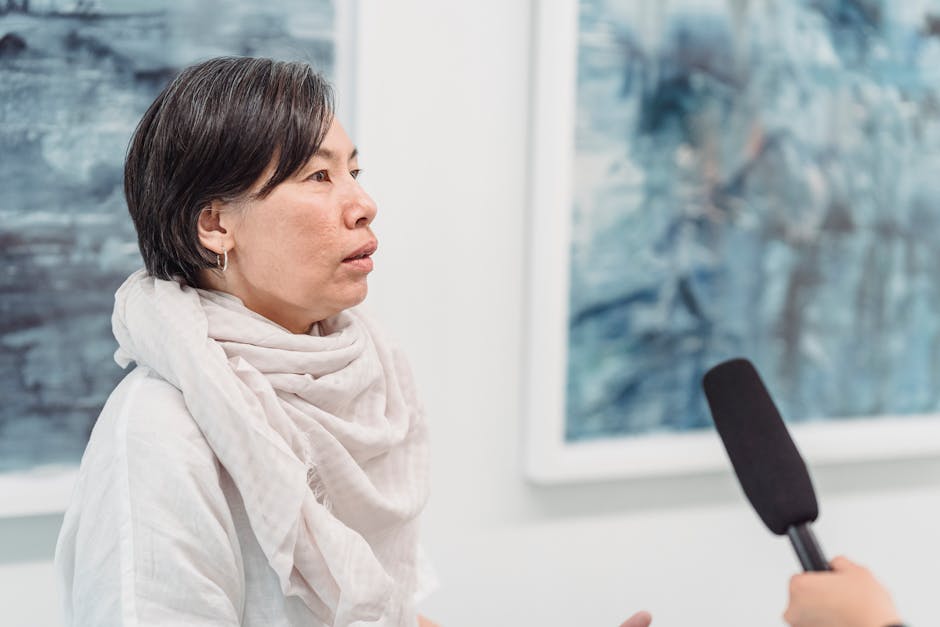 Female artist in conversation during an interview with a microphone in focus.
