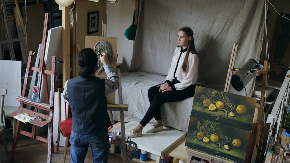 Artist sculpting a portrait in a creative studio with model posing on a sofa.